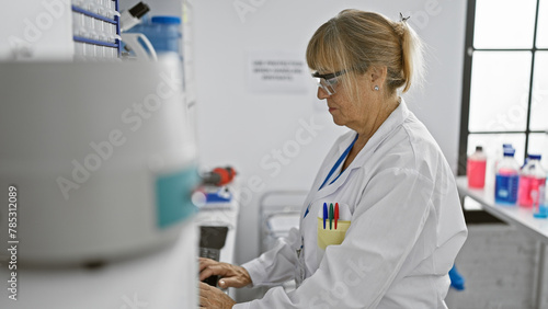 In lab bliss  middle age blonde scientist woman immersed in research  working at computer in laboratory