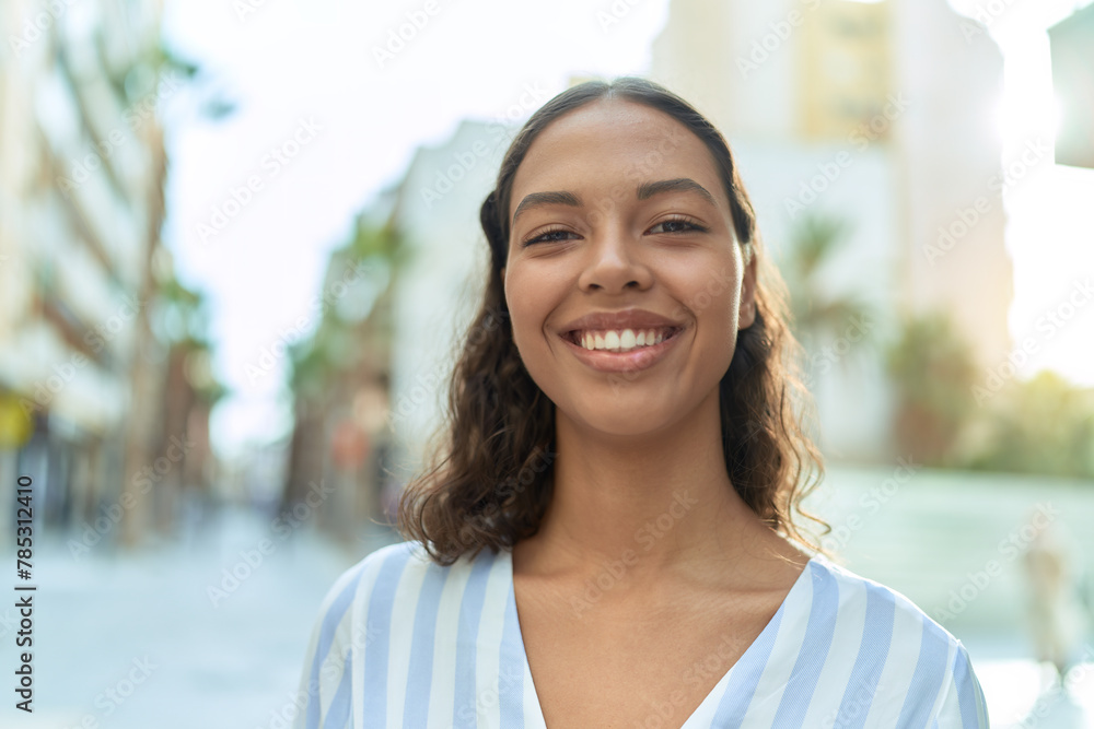 Young african american woman smiling confident standing at coffee shop terrace