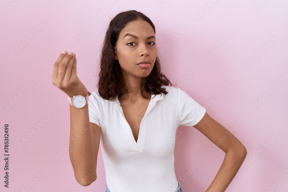 Young hispanic woman wearing casual white t shirt doing italian gesture with hand and fingers confident expression Young hispanic woman wearing casual white t shirt doing italian gesture with hand and fingers confident expression