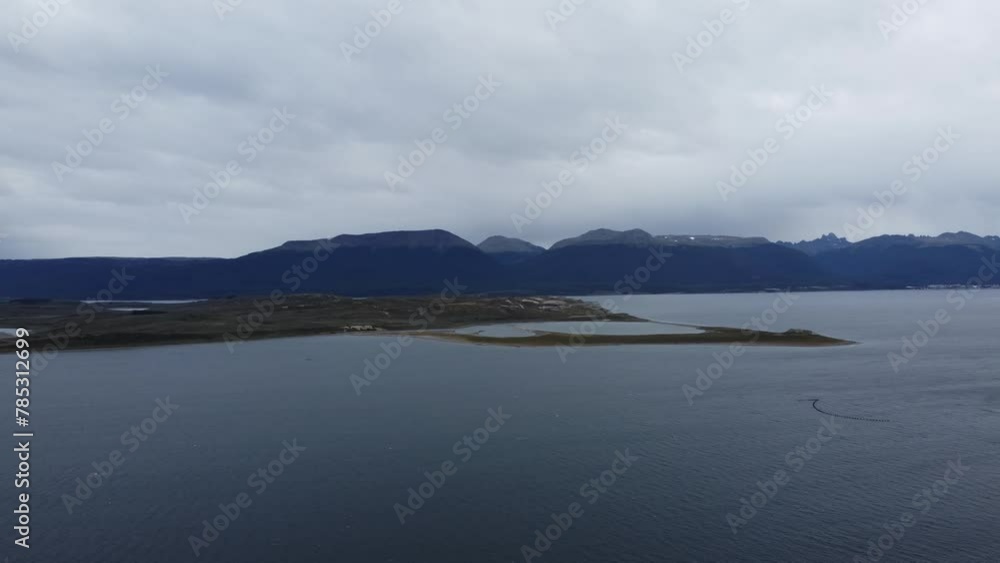 Camera pans across the Beagle Channel on a gloomy cloudy day with rain in the distance and small island in the channel Camera pans across the Beagle Channel on a gloomy cloudy day with rain in the distance and small island in the channel