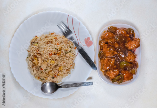 Tasty Chinese cuisine of chicken fried rice with boneless chilli chicken on white background