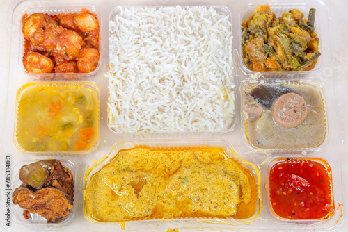 Indian Bengali Mixed Thali meal with vegetarian and non-vegetarian dishes, comprising plain rice, vegetable dishes along with spicy fish curry. © Roop Dey