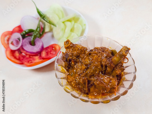 Spicy Indian chicken gravy masala, cooked in Bengali style, served with vegetable salad.