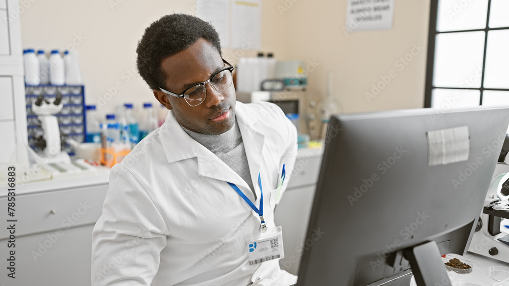 African american man analyzing data on computer in laboratory setting, exuding professionalism and focus. African american man analyzing data on computer in laboratory setting, exuding professionalism and focus.