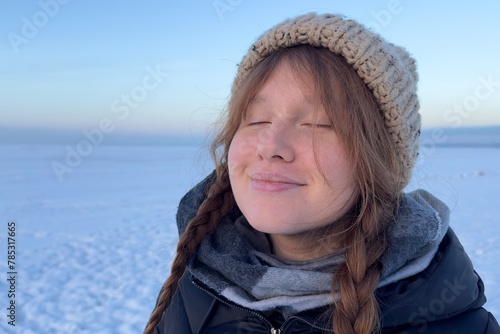 young positive woman with pigtails smiling.have fun, teenager walks on nature, sunrise or sunset winter landscape background