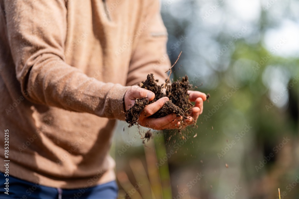 Obraz premium farmer holding soil in hand and pouring soil on ground. connected to the land and environment. soil agronomy in australia. soil heath study