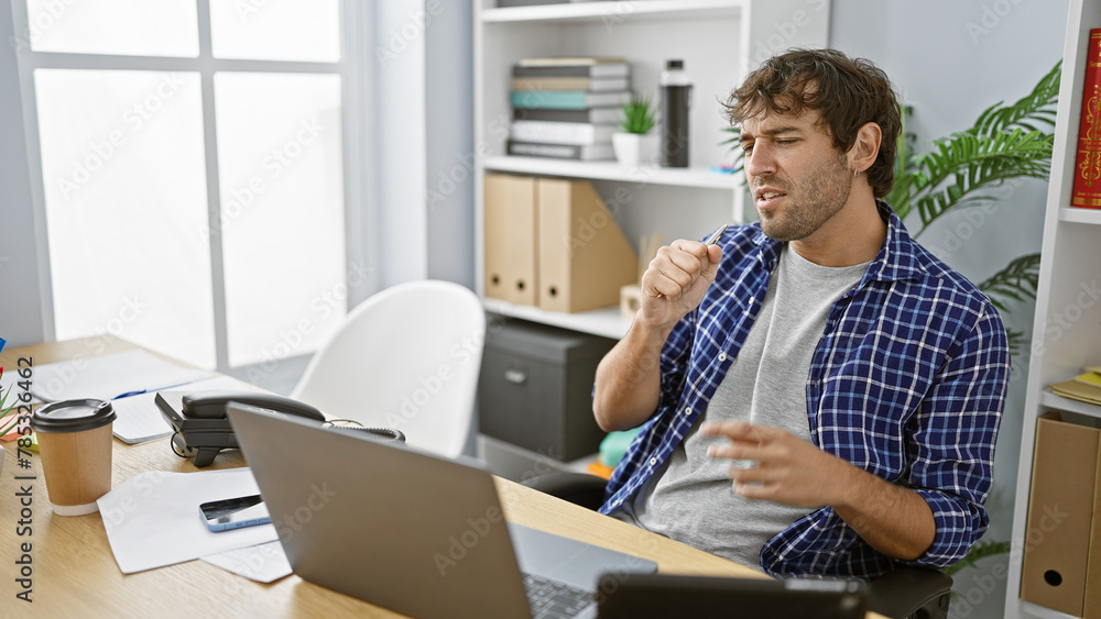 Hard-working young man harmonizing his professional responsibilities, singing songs while listening to music on his laptop in the business office Hard-working young man harmonizing his professional responsibilities, singing songs while listening to music on his laptop in the business office