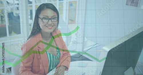 Image of financial data processing over biracial businesswoman in office photo