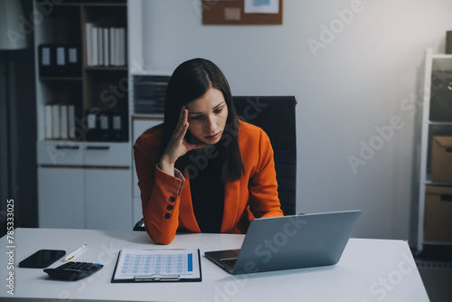 Portrait of tired young business Asian woman work with documents tax laptop computer in office. Sad, unhappy, Worried, Depression, or employee life stress concept