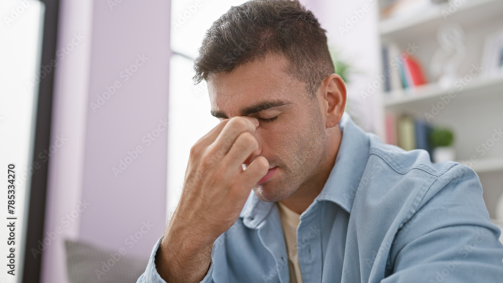 Handsome young hispanic man sunk in sadness, sitting alone on sofa, stressed, facing emotional crisis in home's living room interior Handsome young hispanic man sunk in sadness, sitting alone on sofa, stressed, facing emotional crisis in home's living room interior