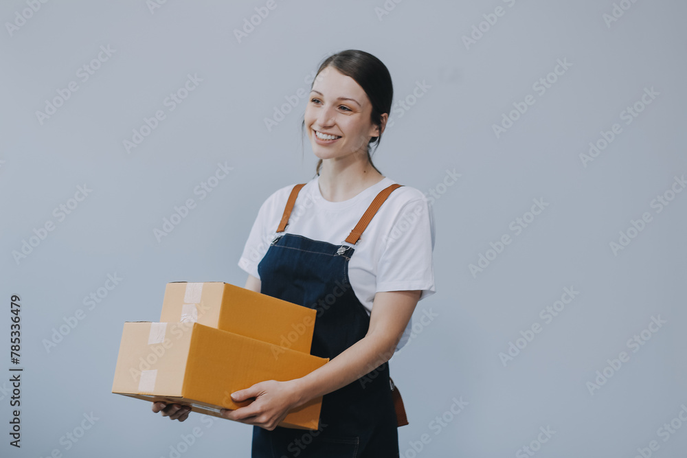 Smiling Asian woman in casual clothes holding a cardboard box mockup while standing against an isolated white background. shipping business concept Smiling Asian woman in casual clothes holding a cardboard box mockup while standing against an isolated white background. shipping business concept