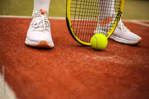 Young woman playing tennis on court. Close-up details of Tennis player equipment. Sport concept. © RetoricMedia