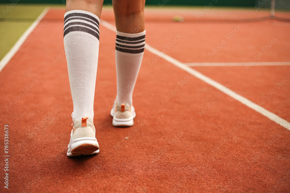 Young woman playing tennis on court. Close-up details of Tennis player equipment. Sport concept.
