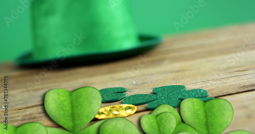 Image of st patrick's day shamrock and green hat on green background