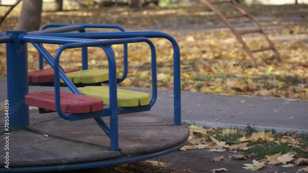 Autumn in the city. Empty children playground. Old carousel is spinning. Sunny warm day. Kharkiv, Ukraine before the war Autumn in the city. Empty children playground. Old carousel is spinning. Sunny warm day. Kharkiv, Ukraine before the war