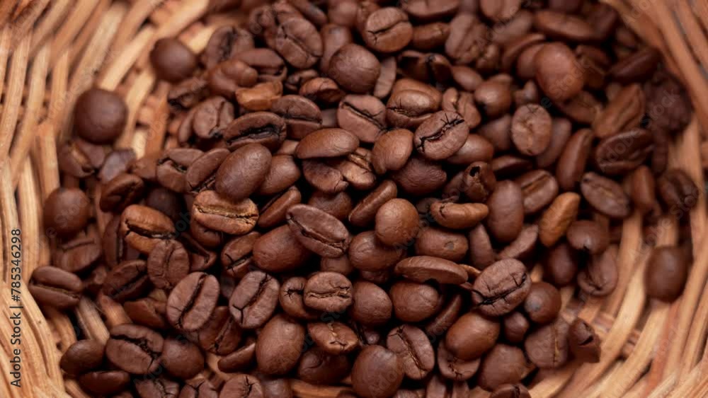 Roasted Arabica coffee beans in wicker rattan bowl. Aroma abundance. Top view. Rotation Roasted Arabica coffee beans in wicker rattan bowl. Aroma abundance. Top view. Rotation