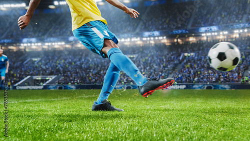Aesthetic Shot Of Athletic Hispanic Footballer Shooting A Penalty Kick On Stadium With Crowd Cheering. Player Scoring a Goal At an International Soccer Championship Final Match With Fans On Tribune photo