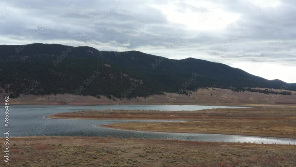 Drone view of Eagle Nest Lake on Highway 64 in the mountians of New Mexico, USA, in a cold autumn day with fog coming down from the peaks into the water. Drone view of Eagle Nest Lake on Highway 64 in the mountians of New Mexico, USA, in a cold autumn day with fog coming down from the peaks into the water.