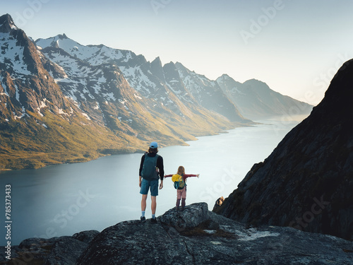 Father and daughter hiking together in northern Norway family vacations active healthy lifestyle adventure outdoor dad with child enjoying mountains and fjord of Kvaloya island photo