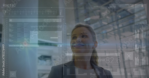 Image of data processing on screens over smiling caucasian businesswoman in modern building photo