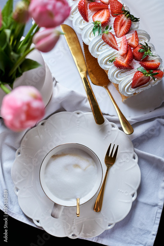 sponge roll with cream, decorated with fresh strawberries