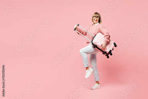Traveler happy elderly woman wear casual clothes hold bag pov guitar isolated on plain pastel pink background studio. Tourist travel abroad in free time rest getaway. Air flight trip journey concept. #785392846