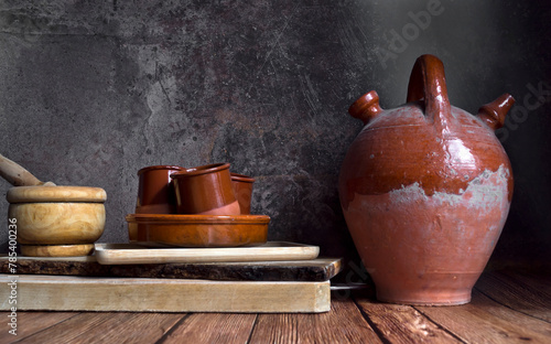 Viejo botijo junto a otros utensilios de madera y cerámica