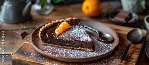 A delectable piece of chocolate pie sits on a white plate on a wooden surface, illuminated by natural light.
