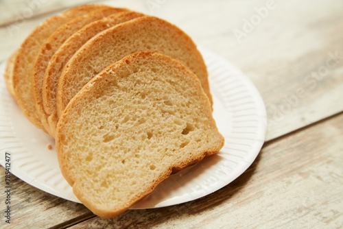 Sliced rye bread lies on a plate on a wooden table, bread on a plate, close-up