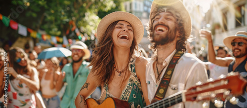 Happy hippie couple playing music and singing with friends in the street, having fun during outdoor party on a sunny day. © Kien