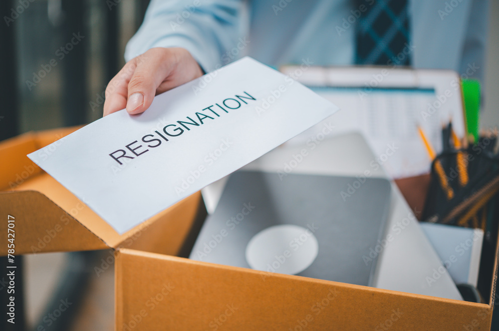 Hand holding a resignation envelope After resigning from work to find a ...