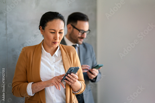 Businessman and businesswoman working and using smart mobile phones on meeting in corporate office