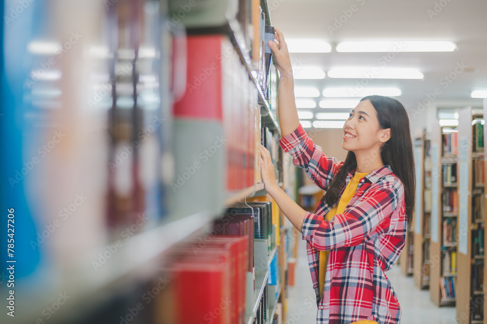 college students looking for books to study, making reports on bookshelves in the library.back to school concept college students looking for books to study, making reports on bookshelves in the library.back to school concept