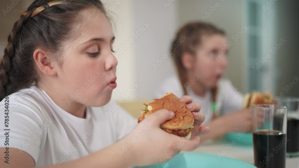 children group eating fast food in the kitchen lifestyle. delicious breakfast unhealthy food concept. children girls eat hamburgers and drink cola in the kitchen indoors. fast food concept children group eating fast food in the kitchen lifestyle. delicious breakfast unhealthy food concept. children girls eat hamburgers and drink cola in the kitchen indoors. fast food concept