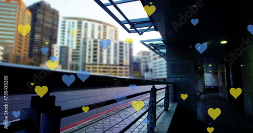 Image of yellow and blue hearts floating over cityscape