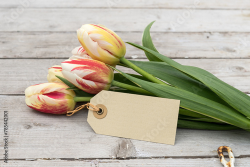 Bouquet of striped tulips in red, yellow and white and card with copy space