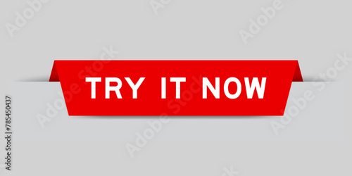 Red color inserted label with word try it now on gray background