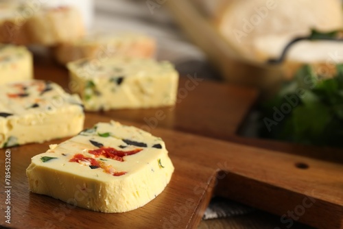 Tasty butter with olives, chili pepper and parsley on table, closeup. Space for text