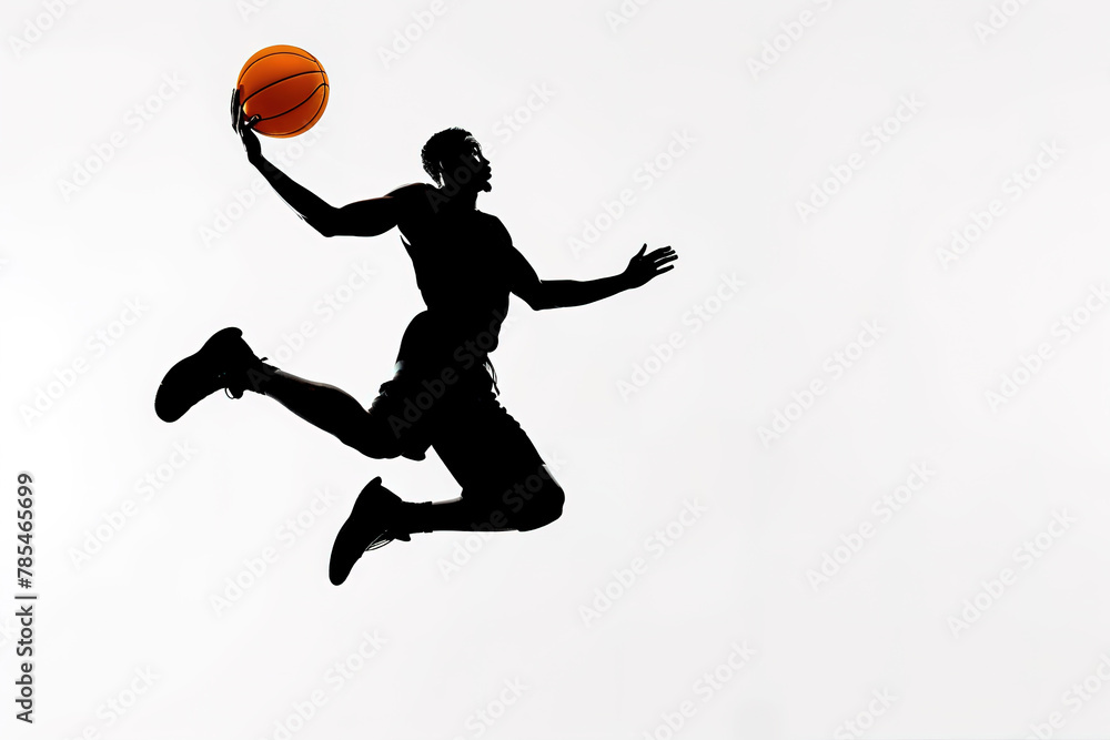Silhouette of a basketball player in mid-air holding a ball.