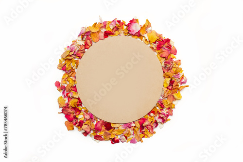 Círculo de madera rodeado de pétalos de rosas de colores sobre un fondo blanco aislado. Vista superior y de cerca. Copy space