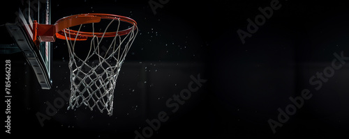 A basketball hoop against a dark background with a focus on the net and rim. © Larisa