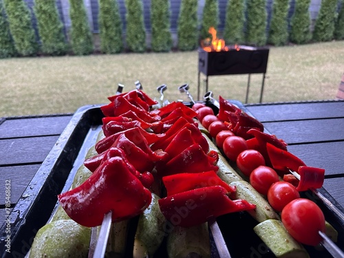 Red pepper and green zucchini on skewers. Grilled vegetables on the grill. Cooking vegetables on fire in nature.