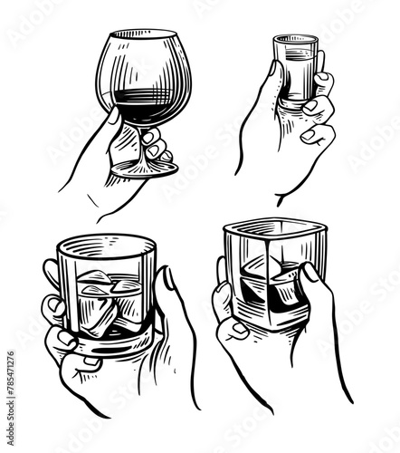 Hands holding various glasses. Whiskey and cognac
