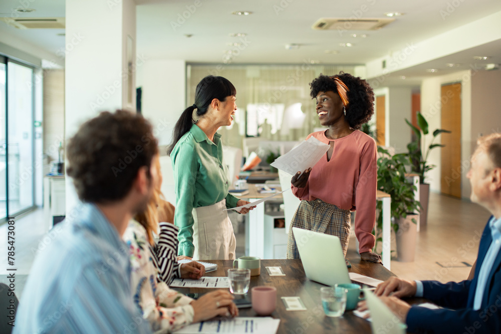 Business meeting in modern office with team of diverse employees discussing project Business meeting in modern office with team of diverse employees discussing project