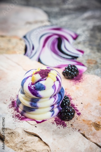 Blueberry, blackberry, honeysuckle, honeyberry smoothie with violet syrup and acai berry powder on a stone background. photo