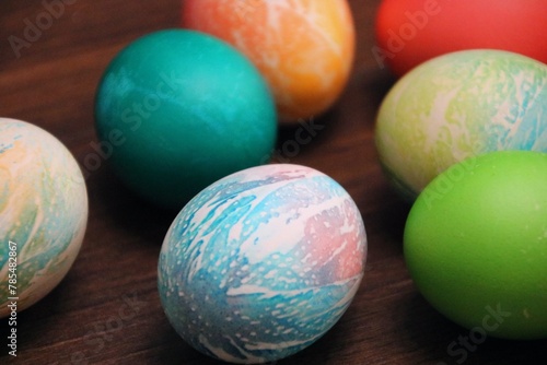 Kolorowe jajka z bliska na brązowym tle © Gabriela