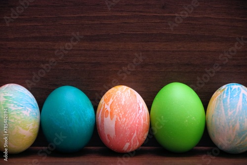 Kolorowe jajka wielkanocne na brązowym tle © Gabriela