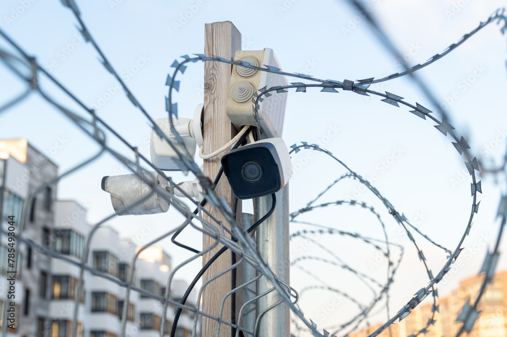 Obraz premium A fence with barbed wire and a camera on top of it.