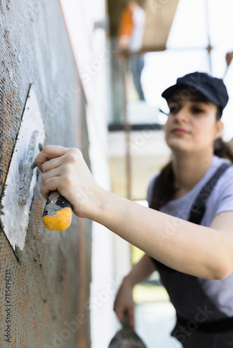 Woman plastering wall with construction tools © zphoto83