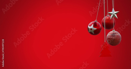 Image of hanging baubles, tree and star swinging against red background